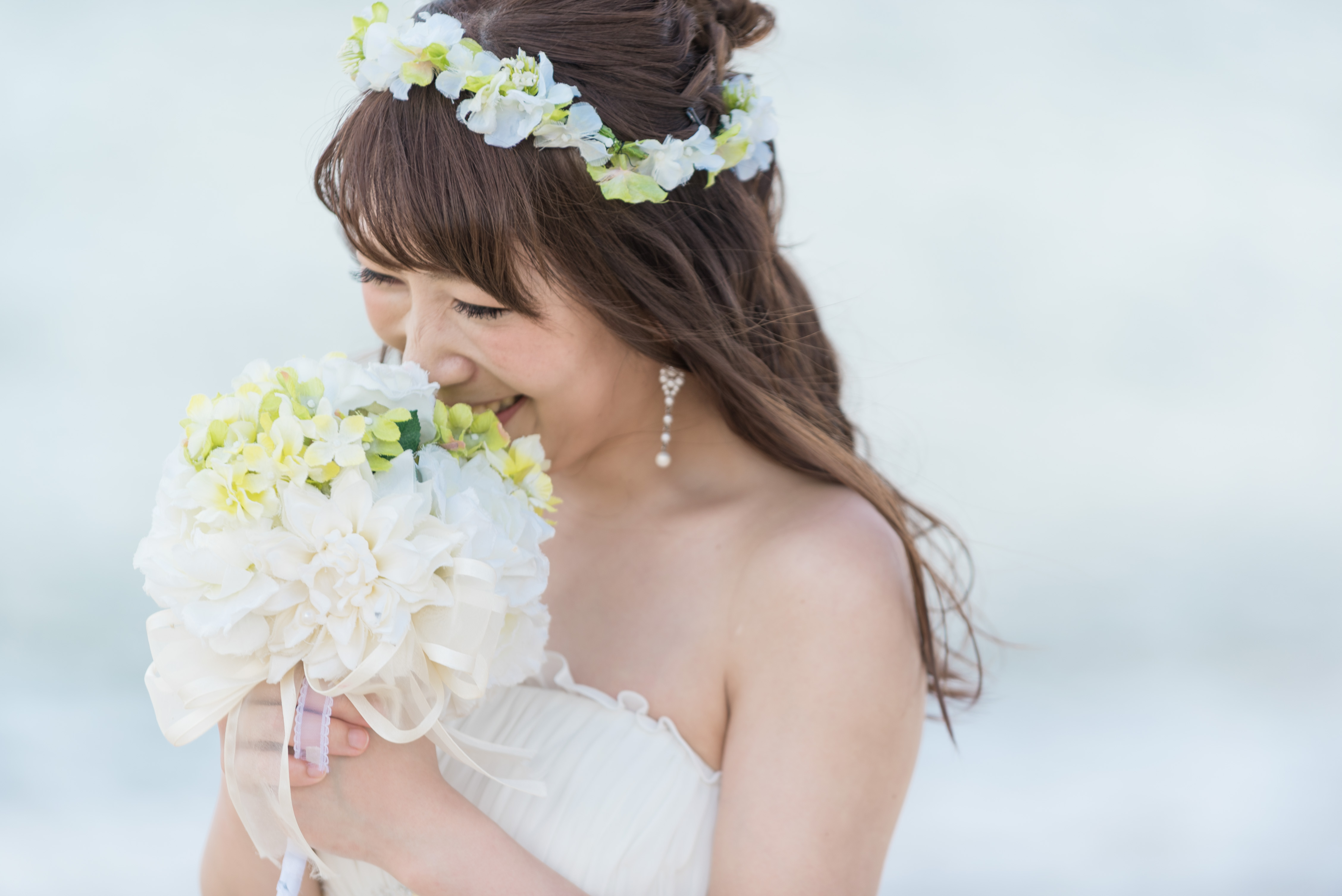 小花の花冠が似合うふんわりダウンヘアが風になびいて沖縄のビーチフォトによく似合う