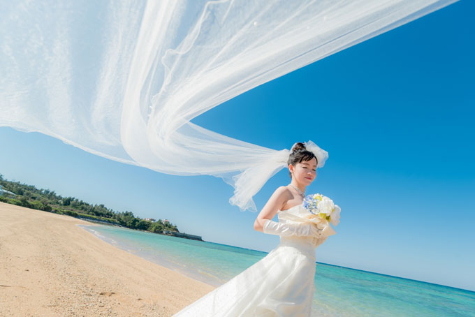 ベールが風になびいて流れているような写真は沖縄のビーチフォトウェディングでおすすめのカットのひとつ