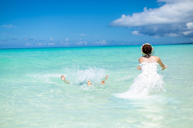 ウェディングドレスのまま海に入って、トラ主ザドレスを目一杯楽しんで｜沖縄ウェディングオンライン