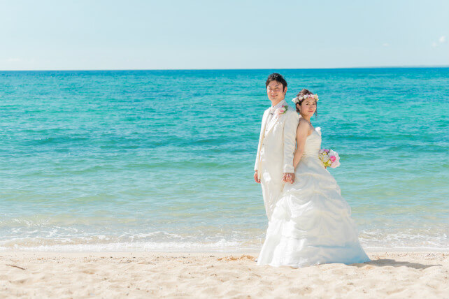 沖縄の海の青を背景に、笑顔が引き立つ花嫁のフォトウェディング
