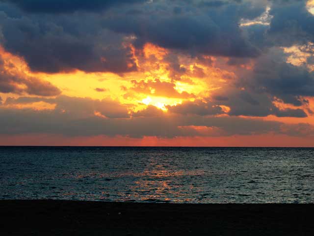 美しい夕焼け空で茜色に染まる嘉陽ビーチ