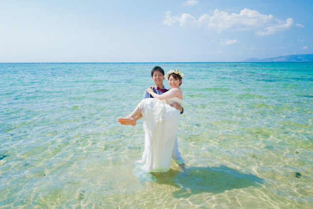 沖縄の海の青を背景に、笑顔が引き立つ花嫁のフォトウェディング