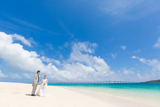 青空とエメラルドグリーンの海を眺めながらゆったりと結婚写真を撮影
